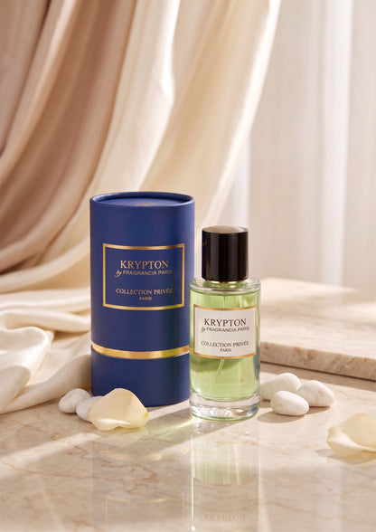 Extrait de parfum Krypton PDS SHOP avec flacon en verre, liquide vert et étui bleu cylindrique sur fond drapé