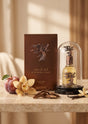 Flacon de parfum PDS SHOP Eternal Oud de Lattafa sous cloche en verre avec boîte, prune, orchidée et copeaux de bois.