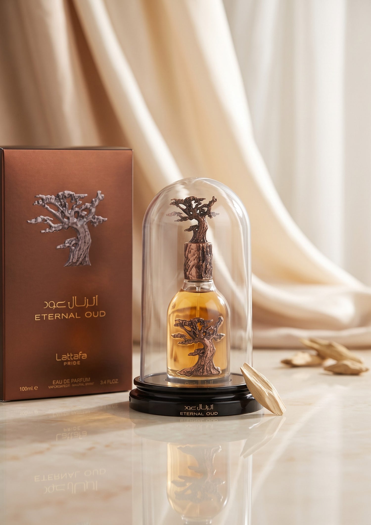 Flacon de parfum Lattafa Eternal Oud sous cloche en verre avec coffret marron sur fond de tissu drapé élégant