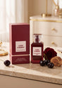 Flacon de parfum Lush Cherry PDS SHOP avec boîte rouge, cerises fraîches et rose sur une table en marbre élégante