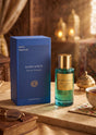 Flacon de parfum PDS SHOP Oudh Coco en verre vert avec bouchon doré, posé à côté de sa boîte bleue sur une table