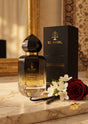 Flacon de parfum PDS SHOP El Nabil Royal Gold avec boîte noire, rose rouge et fleurs blanches sur table en marbre